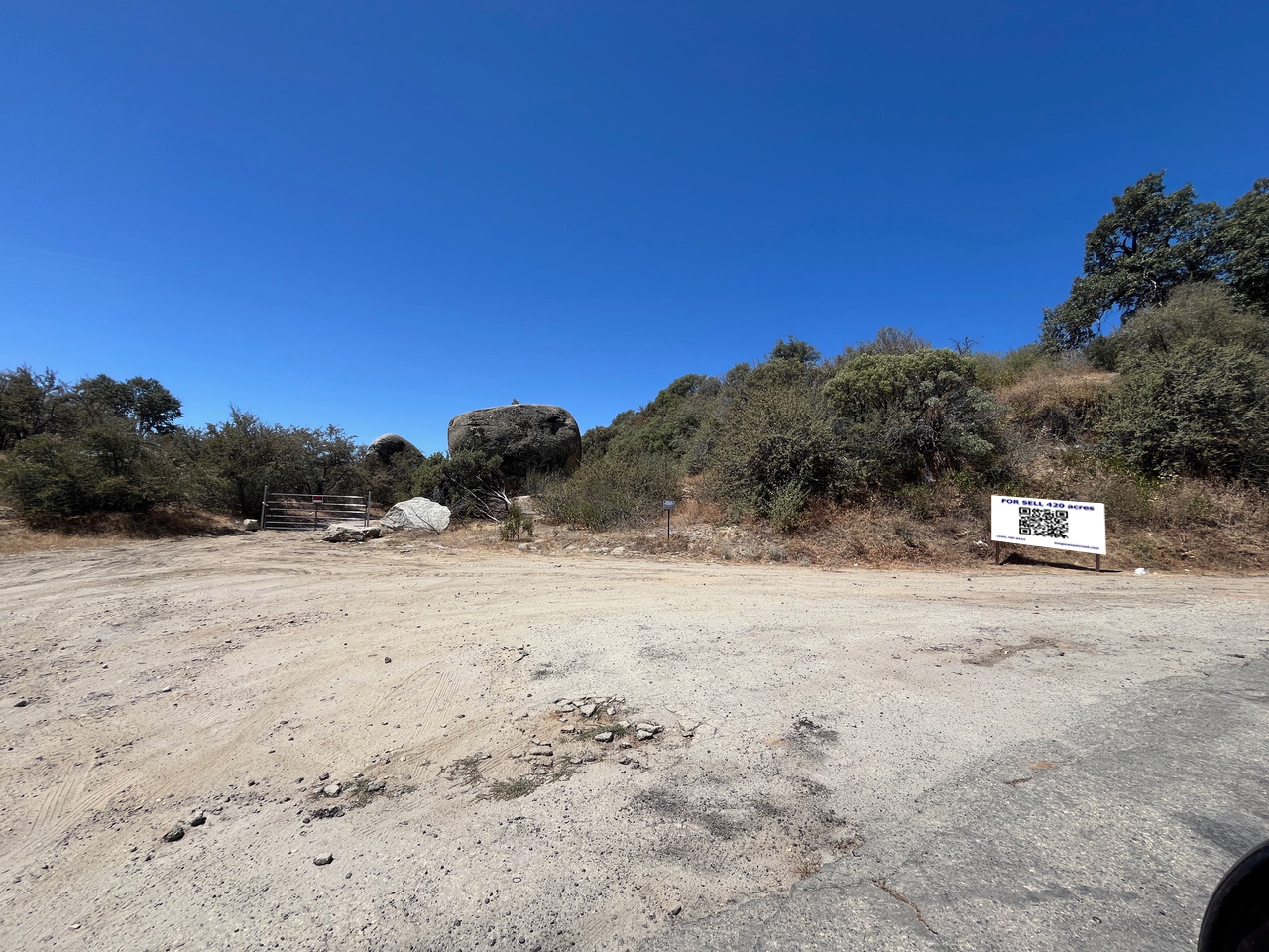 Turnout gate and for-sale sign with QR code at the Kings Canyon property entrance